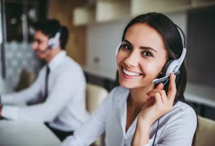 Lone Worker woman sitting in the call center accepting calls from customers with smile on her face